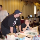 Mr. Nike, aka Lawrence from Basement Boys (Creators of FastHack'em) walks by as Demonger chats with Steve Judd and Elwix at Chicago SWRAP Expo 2004.